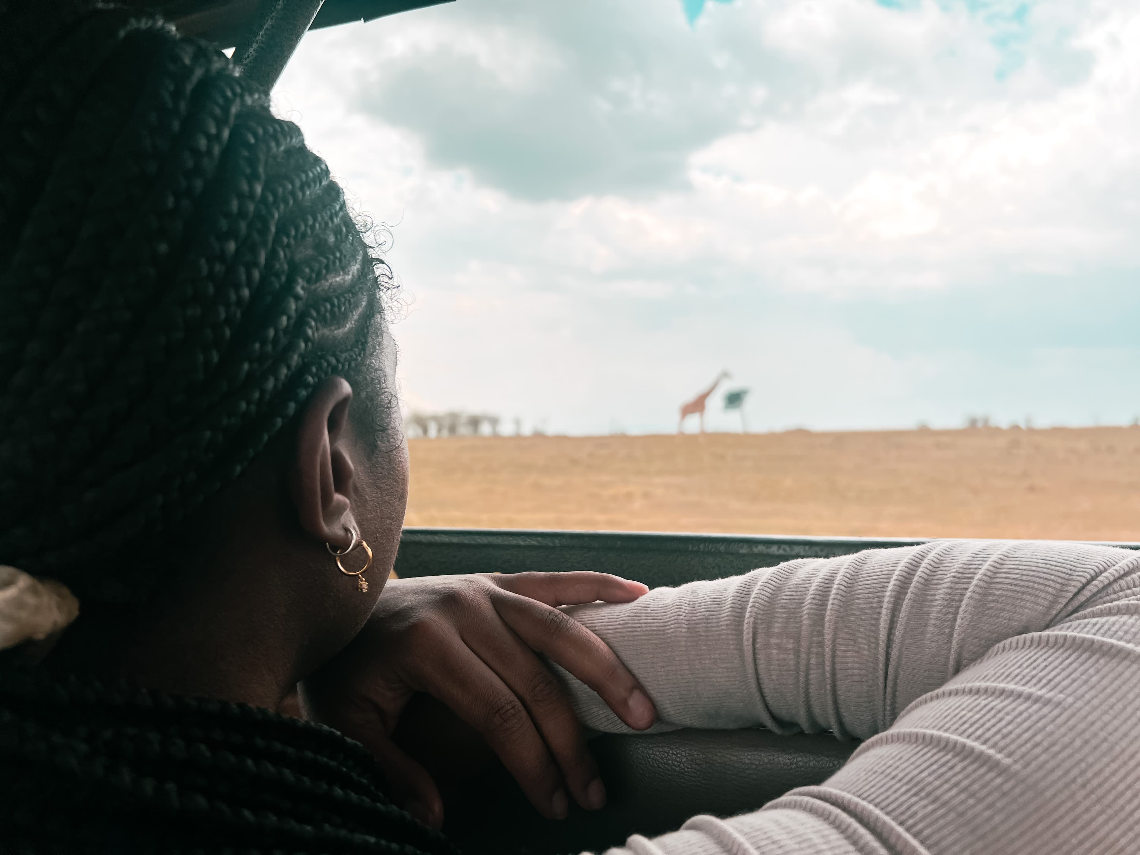 Girl looking at a giraffe.