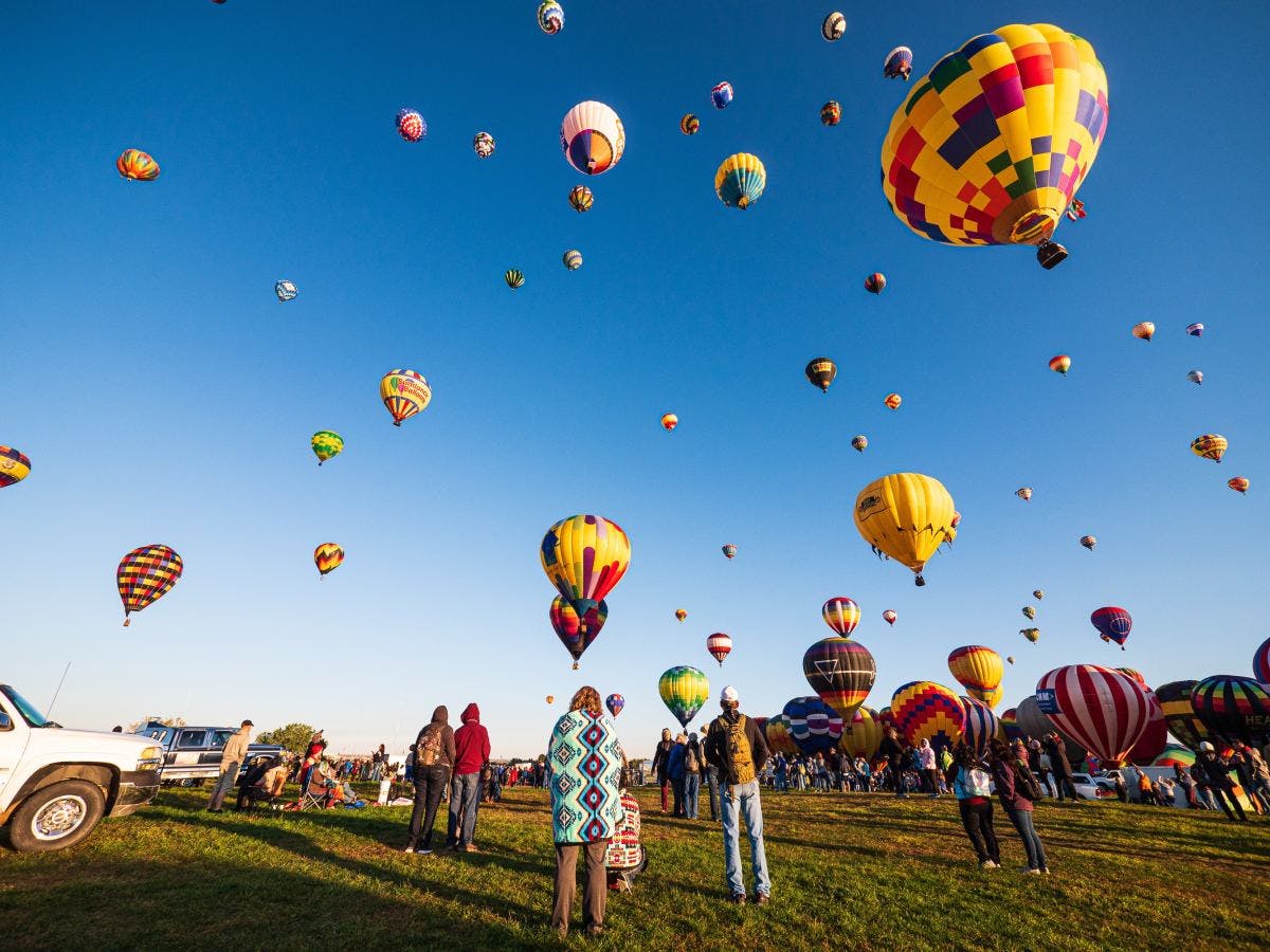 Clear blue sky full of yellow hot air balloons