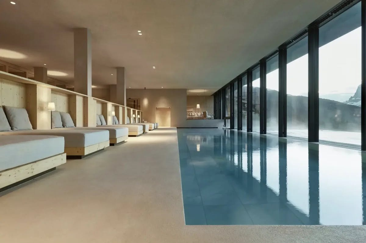 a sleek indoor pool with floor-to-ceiling windows overlooking a mountainous expanse