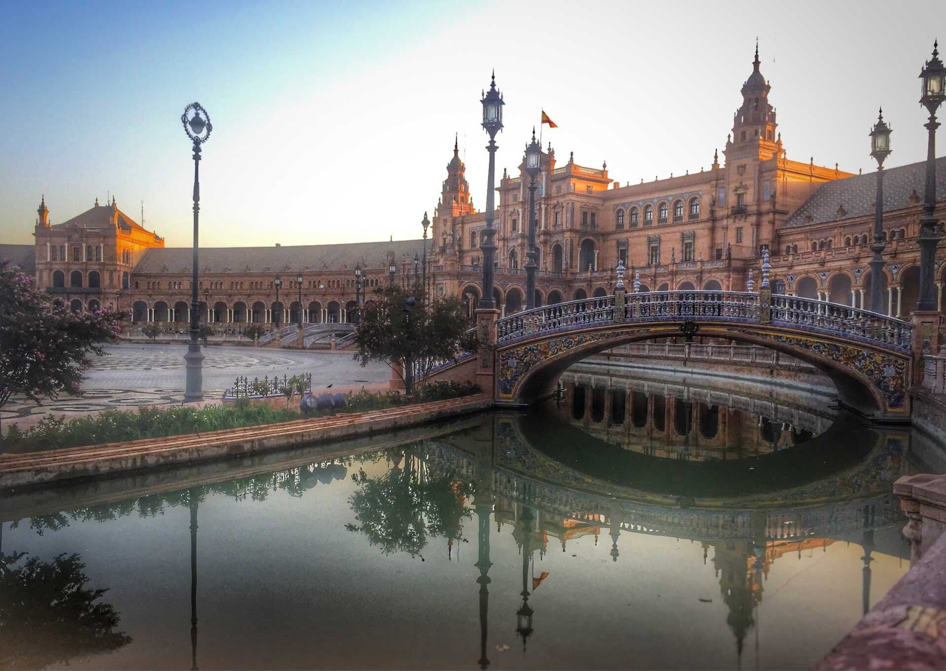 ornate building and plaza over pool in morning light