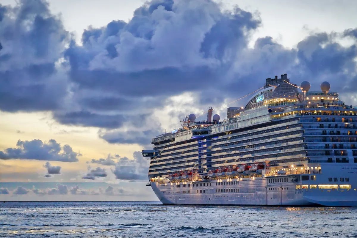 A cruise ship is lit up at dusk while sailing away from St. Thomas (not pictured) in the Virgin Islands