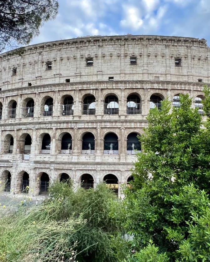 A Colosseum surrounded by green trees