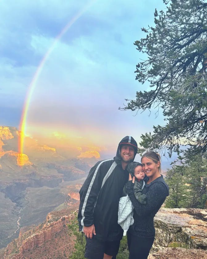 Picture of Jennifer with family and a rainbow in the background over the Grand Canyon