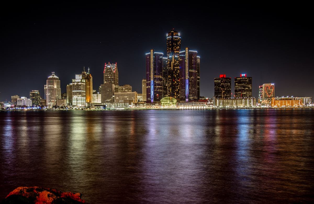 a view of the water and lit-up buildings of Detroit 