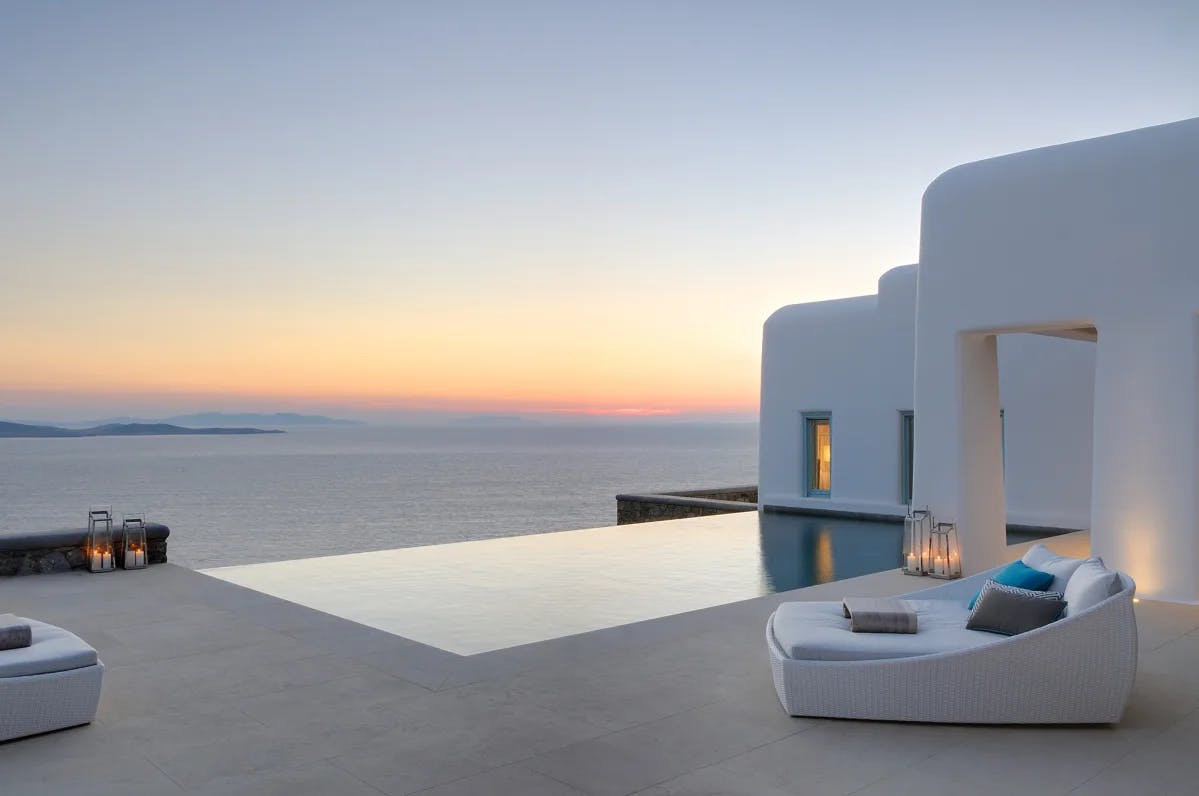 white-walled home with an infinity pool overlooking the sea