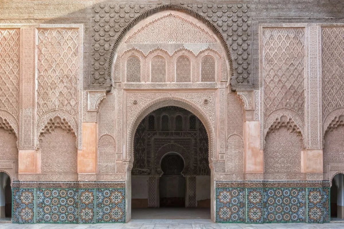 Intricate tile- and column-work on display at a prominent archway at Ben Youssef Madrasa