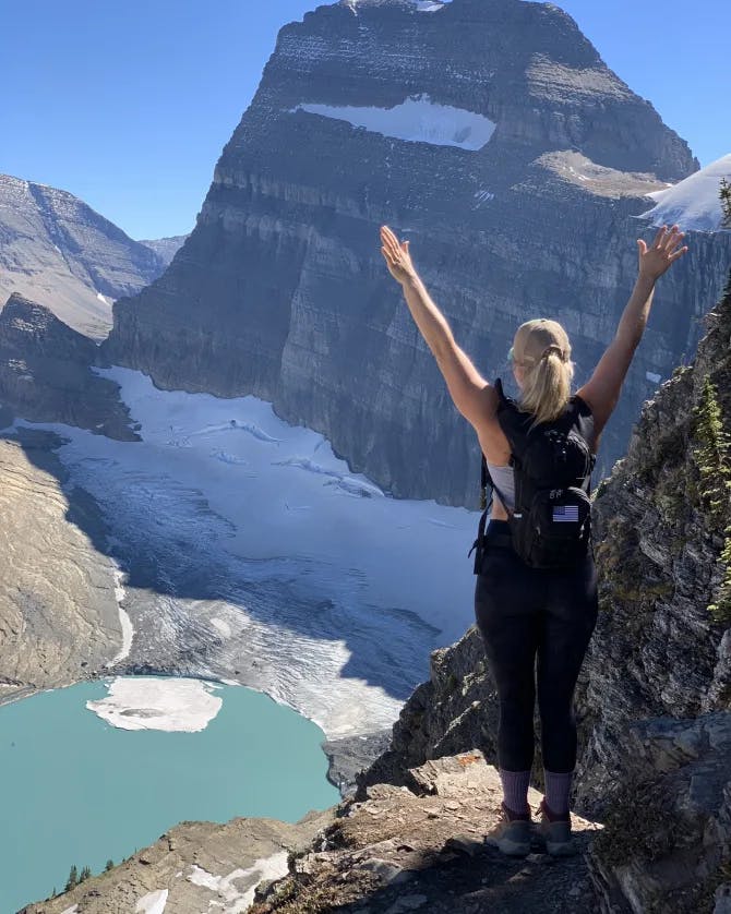 Picture of Jennifer at Glacier National Park with her hands raised above her head