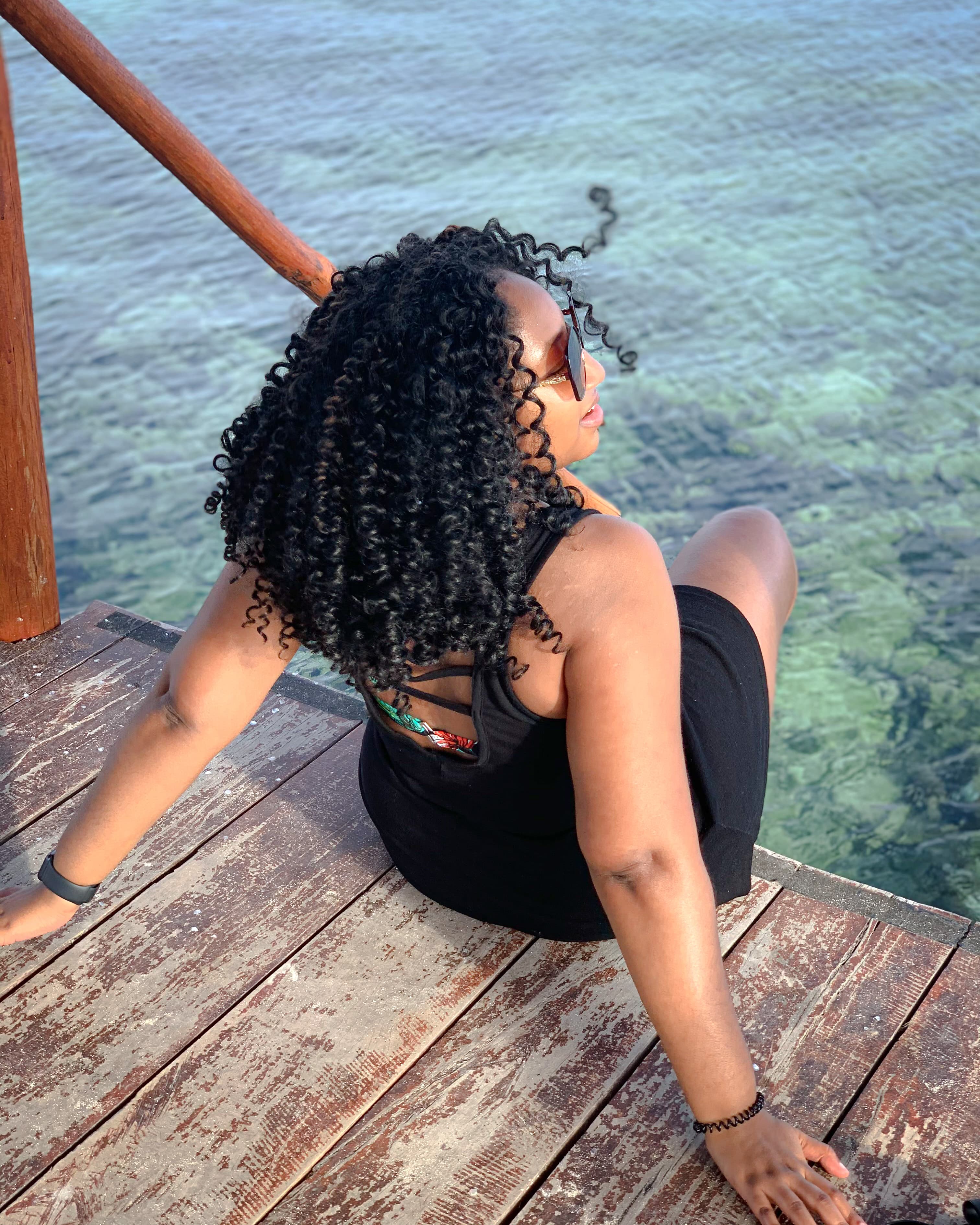 Picture of Joanna wearing black dress sitting with foot in water