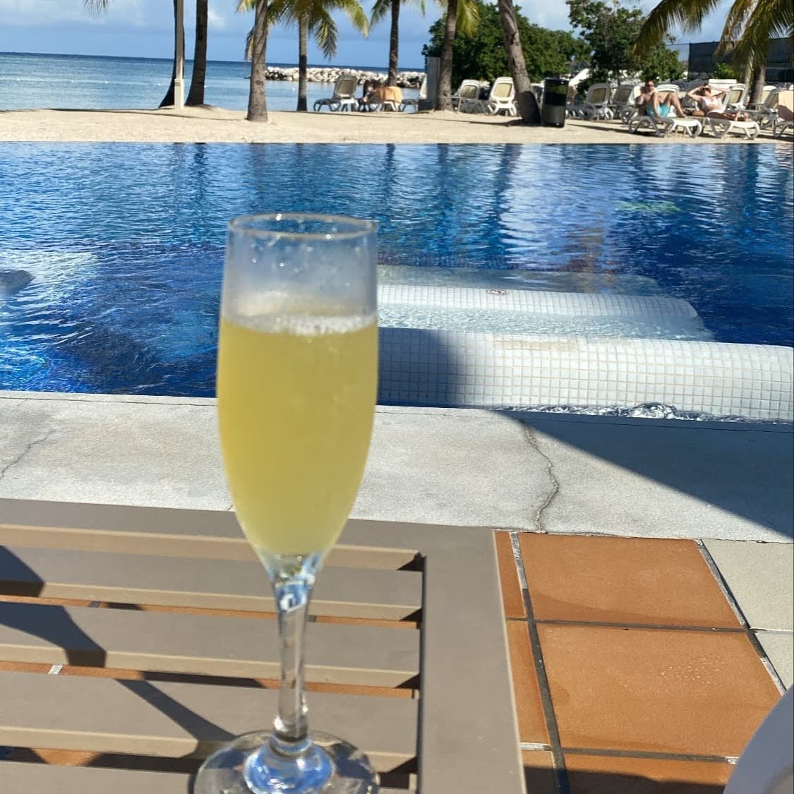 Travel Advisor Kiana Grant having a drink by the pool.