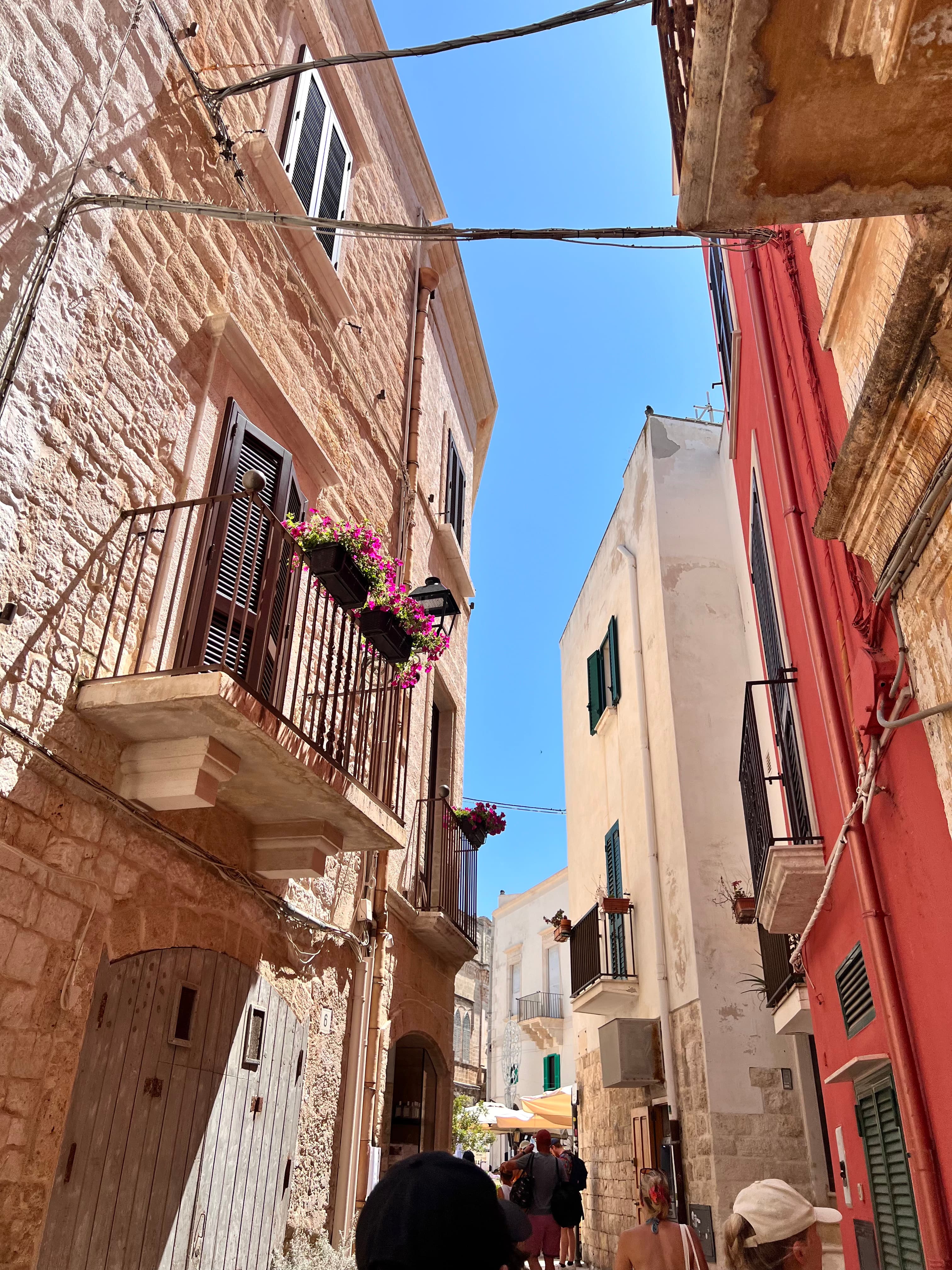 A picture of stone buildings with balconies and flowers set against the blue sky