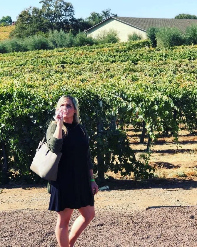 Picture of Nicole standing in a vineyard field.