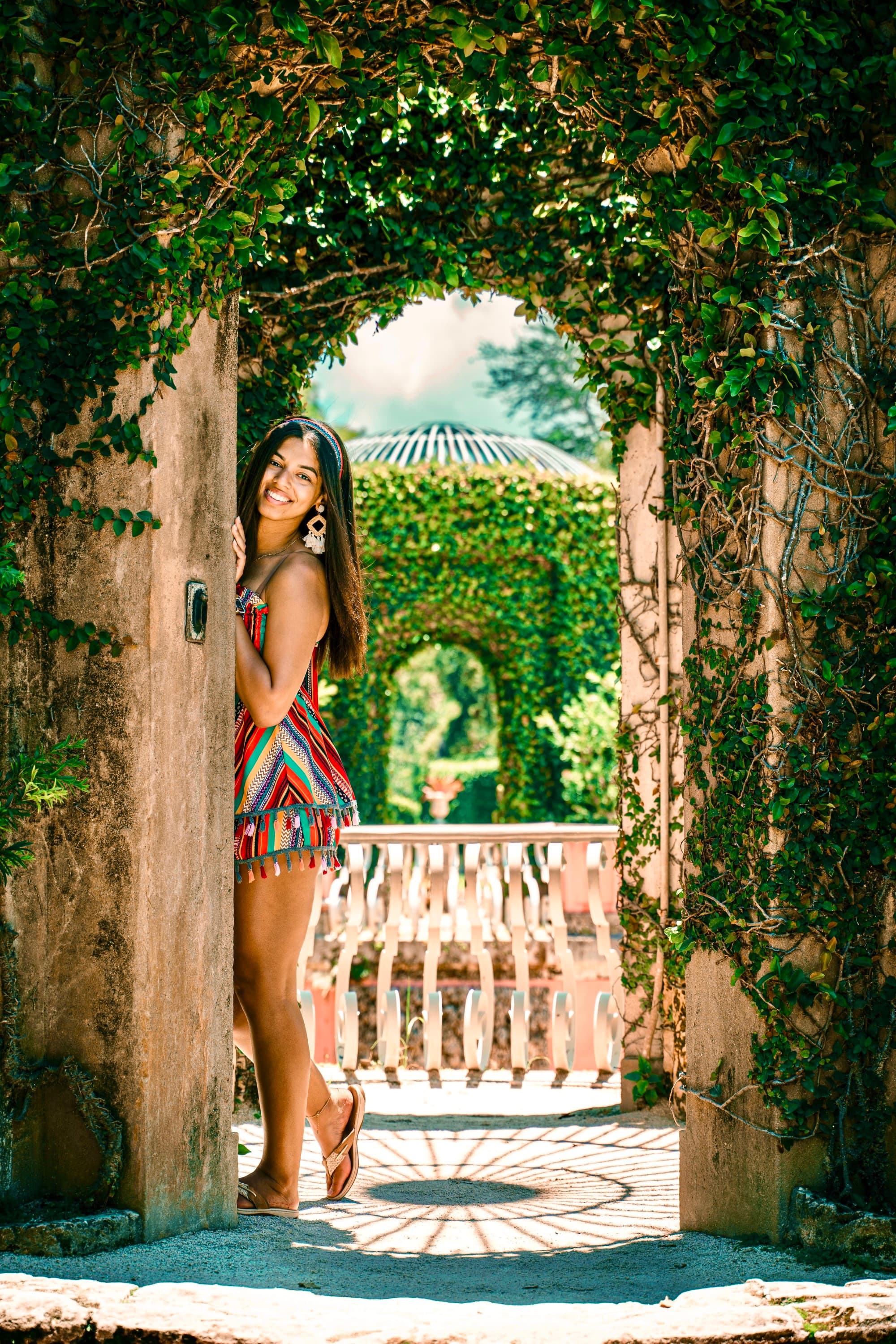 Travel advisor in colorful dress with garden at the back.