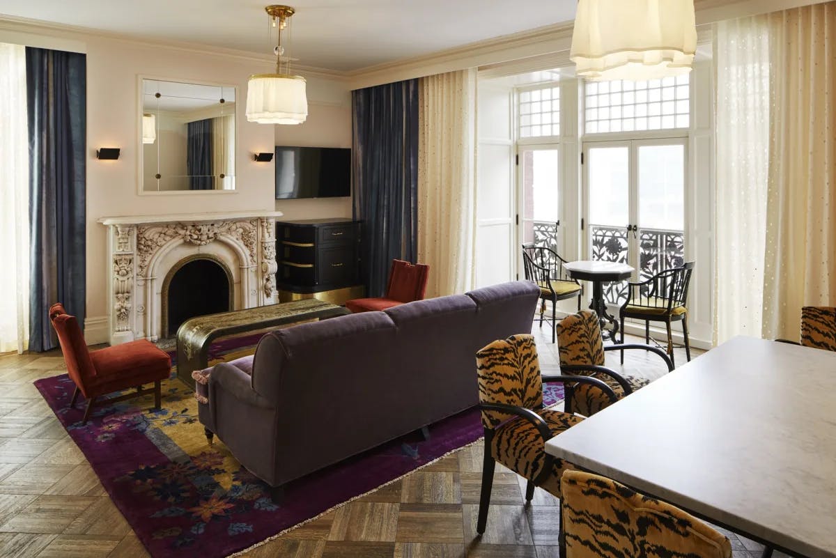 a fancy living room with a purple couch and tiger-printed chairs
