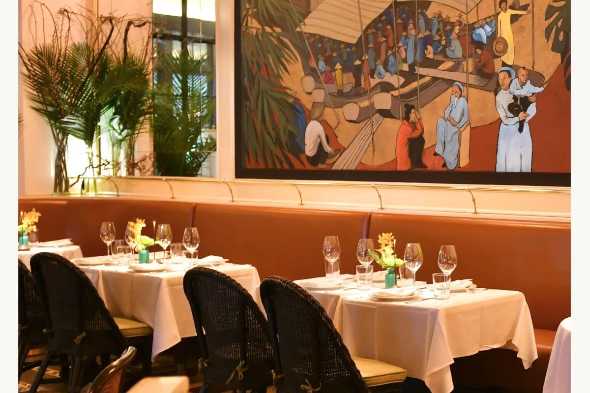 French Vietnamese mural inside a restaurant with tables and chairs