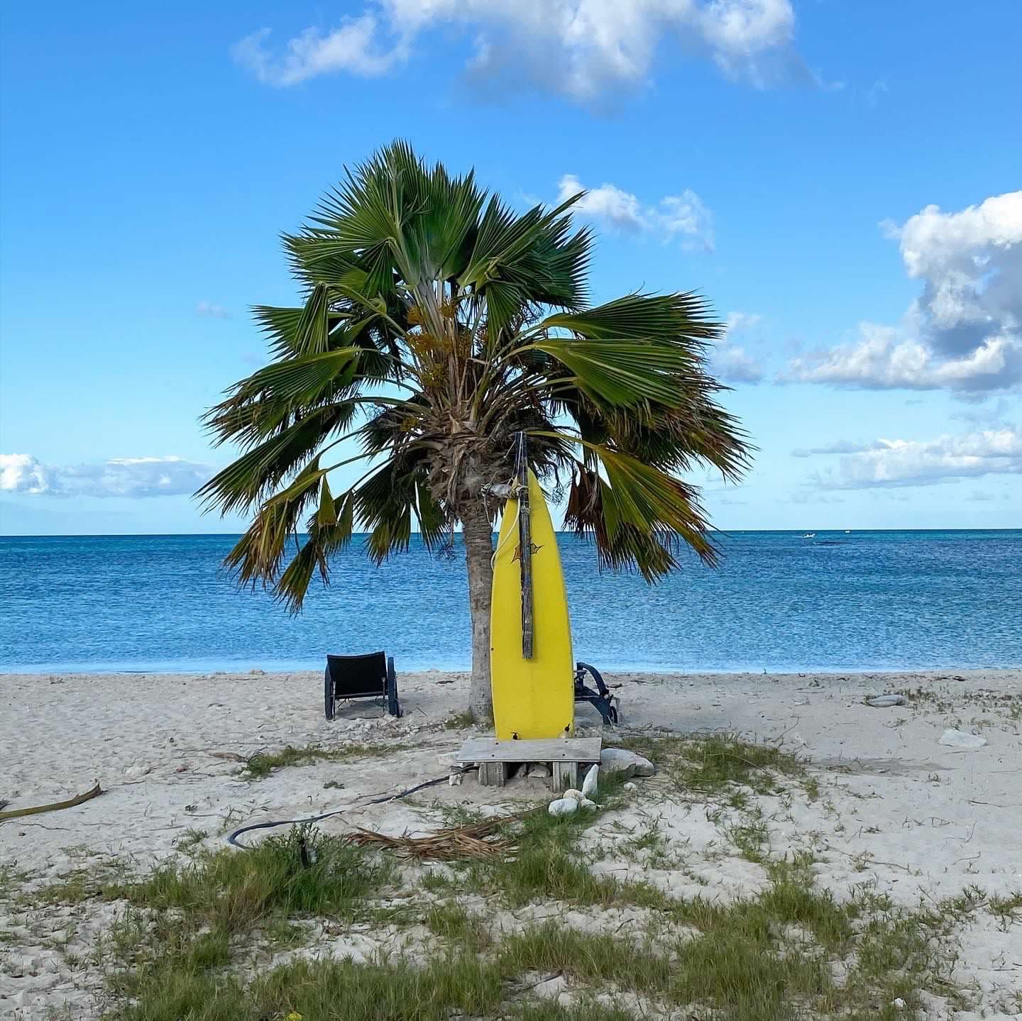 A yellow surfboard on the beach