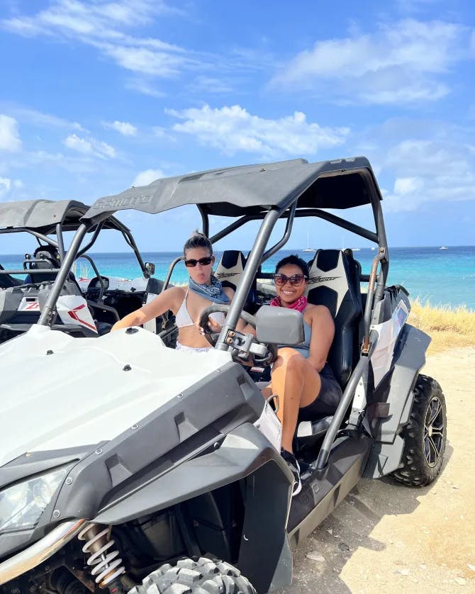 A picture of Ashli in an ATV on the beach with the ocean in the background