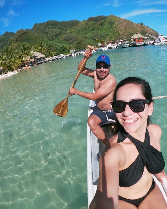 A couple smiling for a selfie on a boat in the water