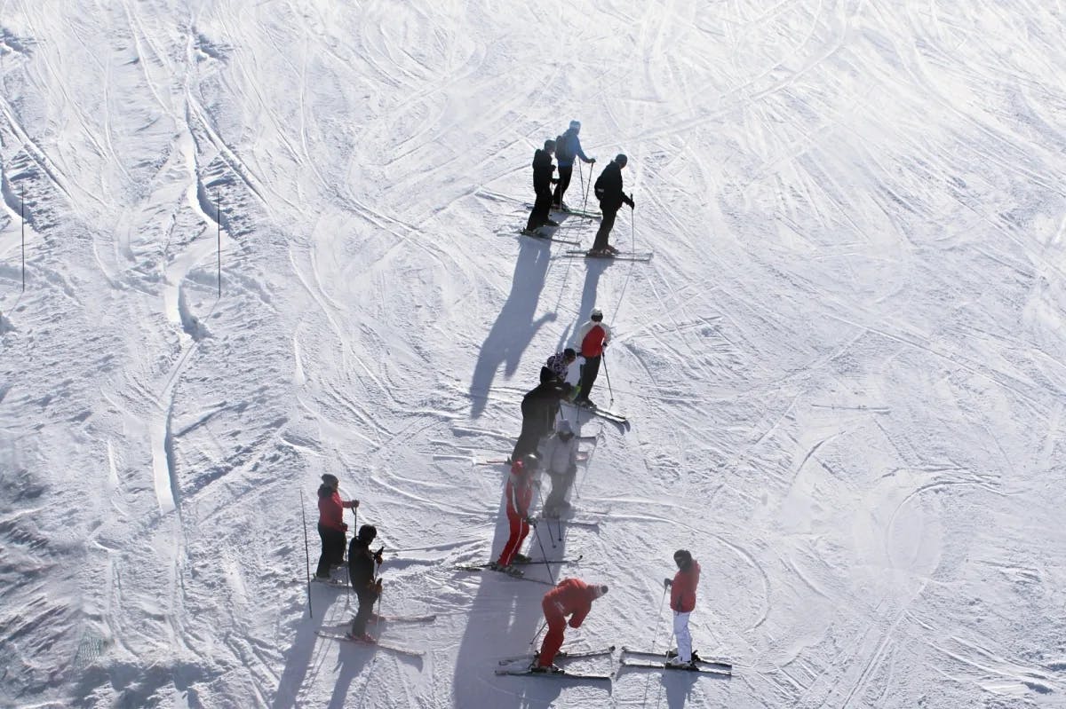 A group of skiers converse on the ski trails at Les Deux Alpes, Mont-de-Lans, France