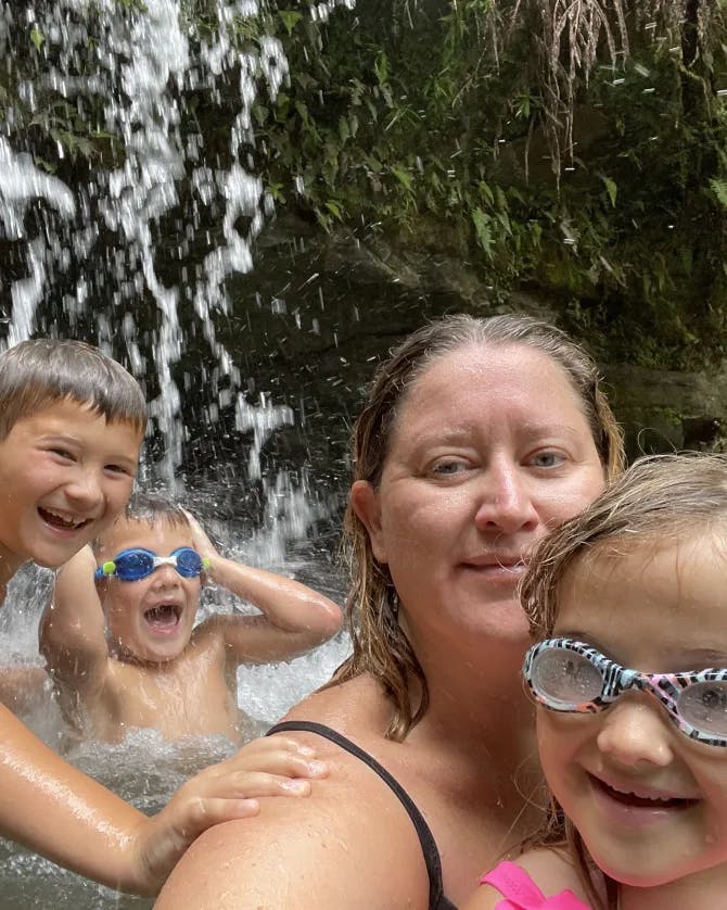 Karyn swimming in a lovely waterfall area with her kids. 