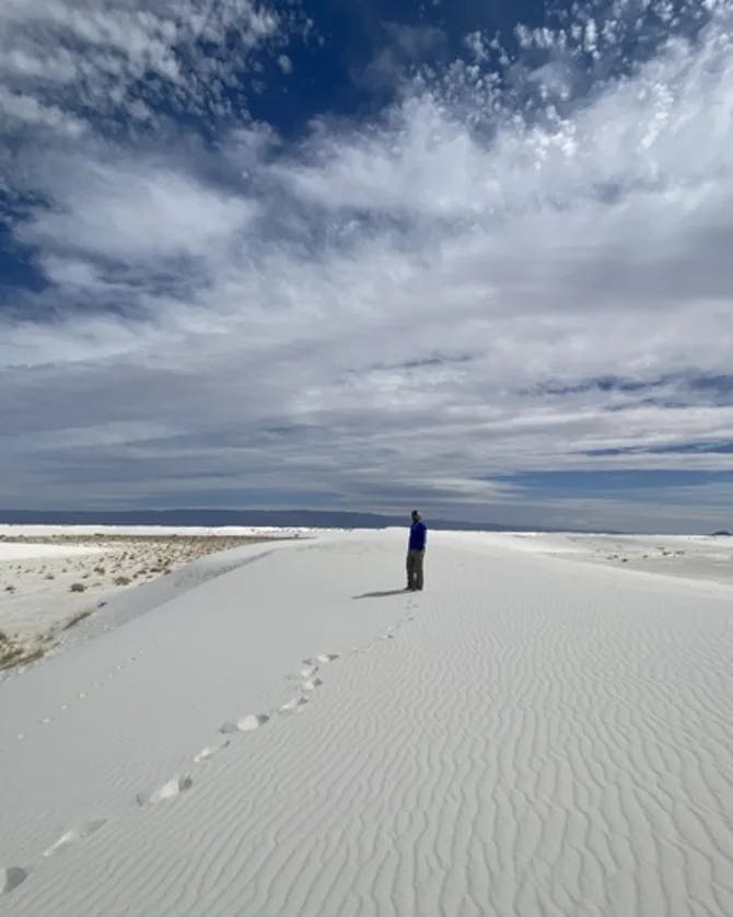 Kimberlie walking in a white sand dune outside.