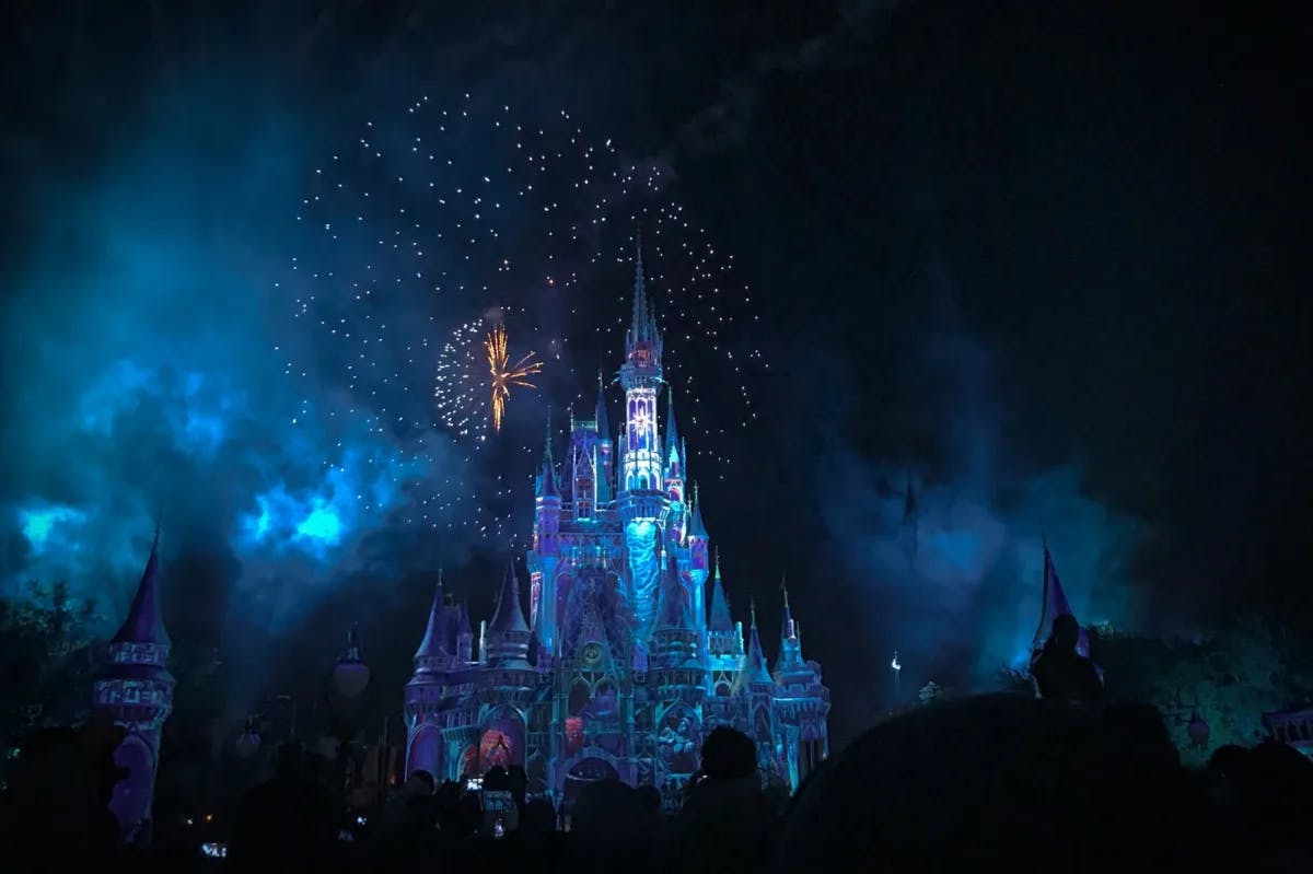 The castle at Magic Kingdom, Disney World lit up at night with the Villains firework show