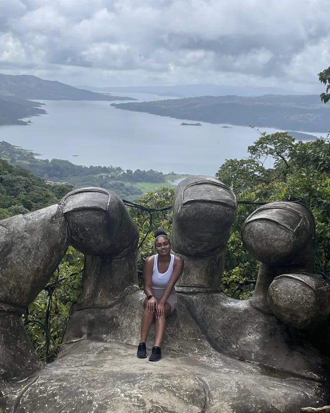 Sitting in a hand sculpture in Costa Rica