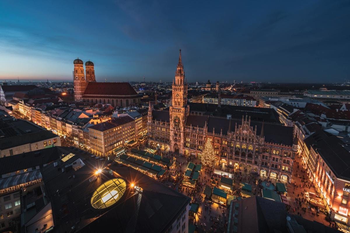 Bavarian buildings in Munich with golden lights at night.