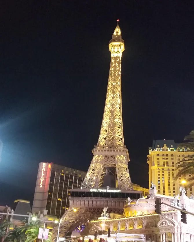 A view of the Eiffel Tower restaurant lit up at night in Las Vegas.