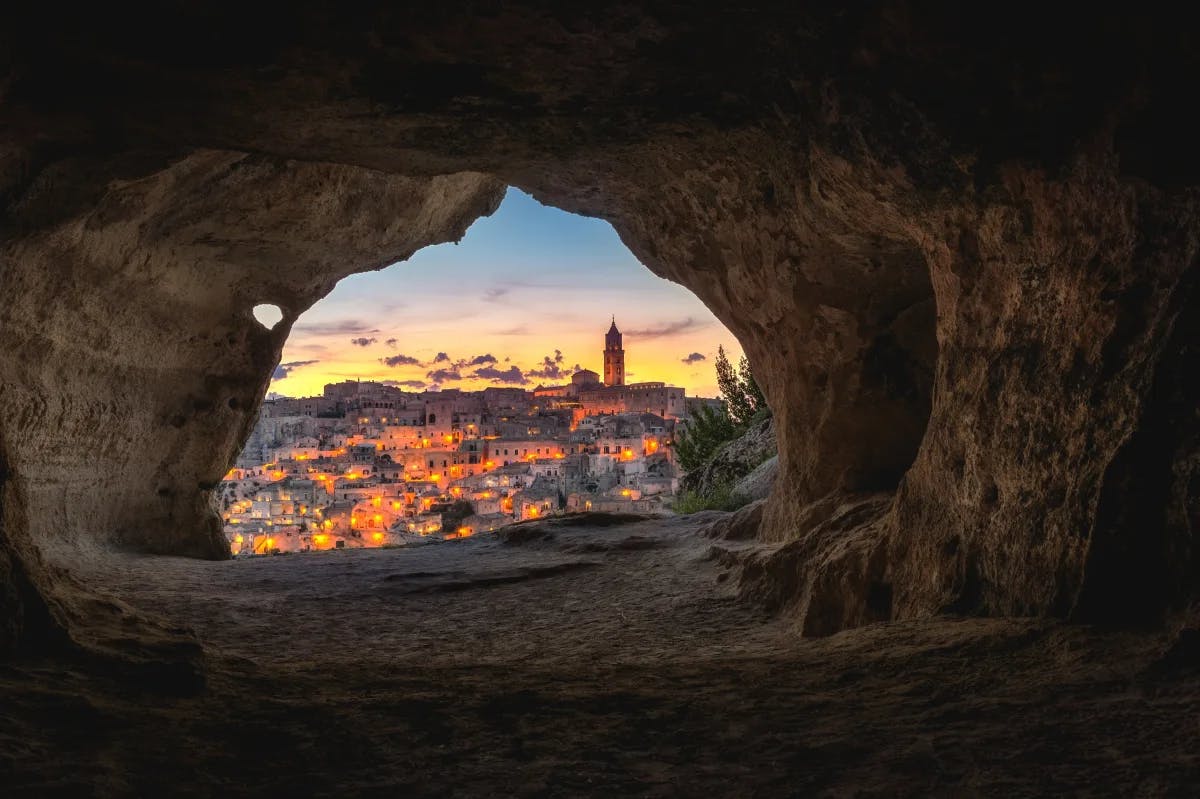 A picture of a brown cave with overview of the city.