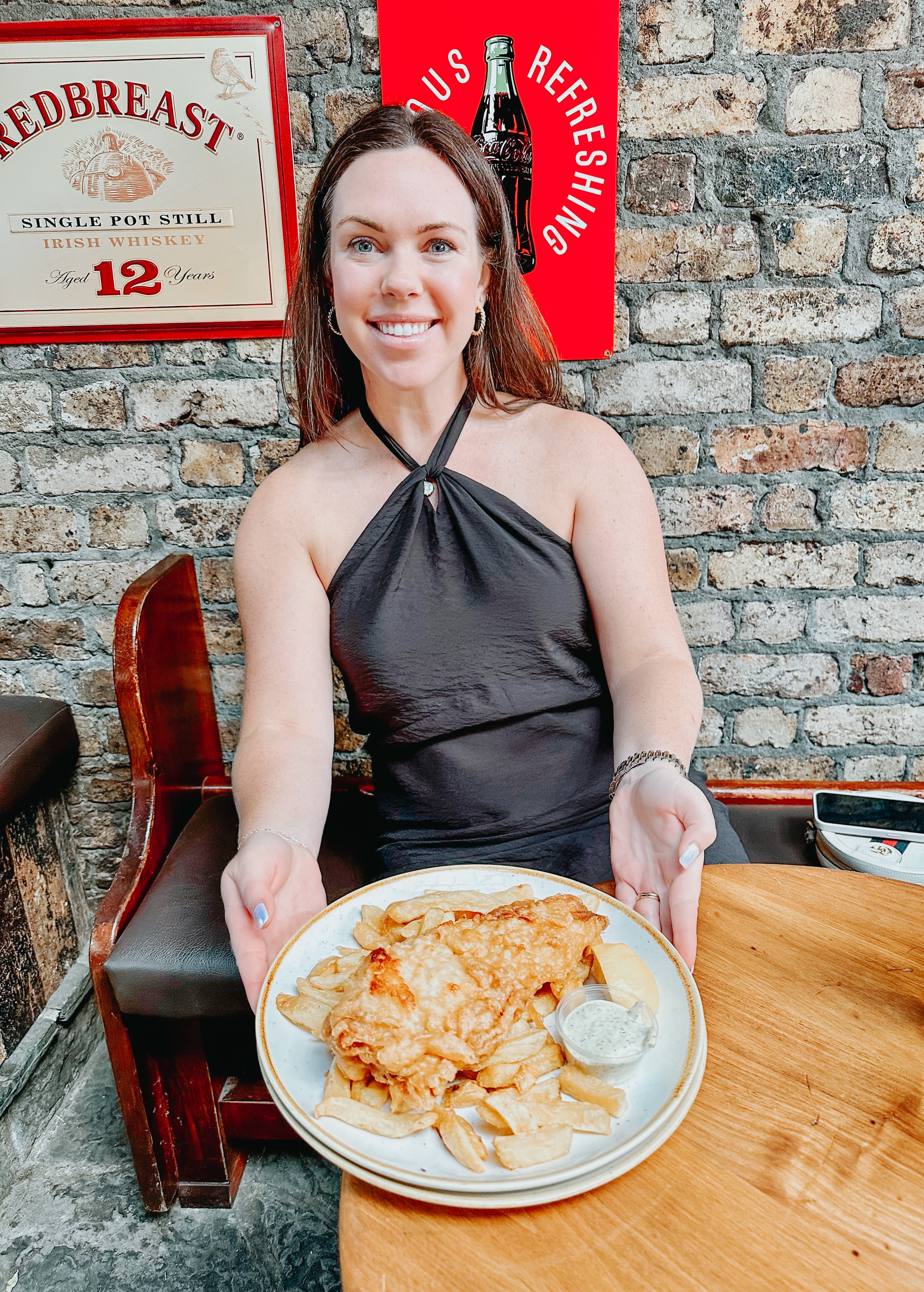 Travel advisor holding a plate of delicious fish and chips.