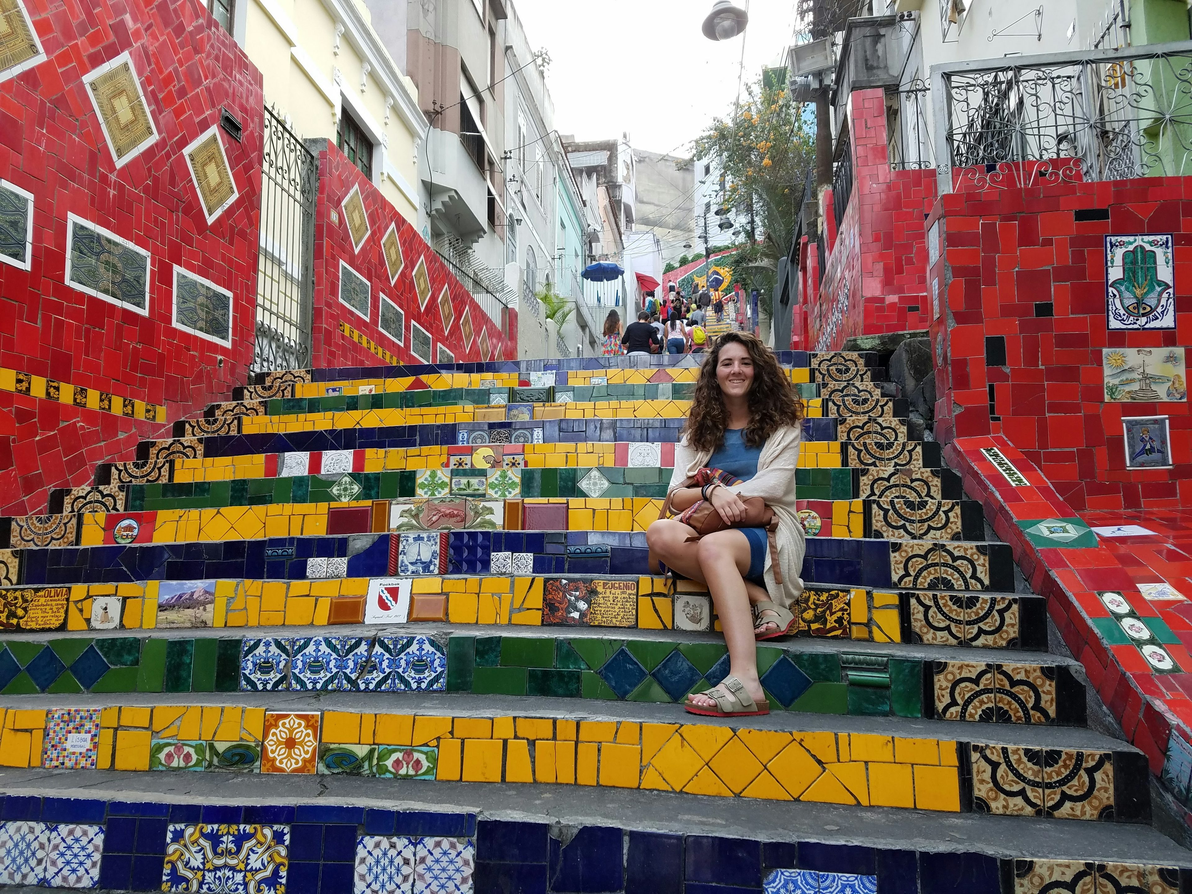 Fora travel agent sitting on colorful stairs on a cloudy day