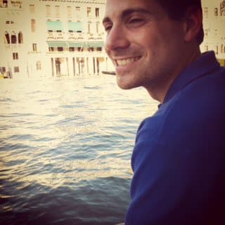 A man on a boat in city canal.