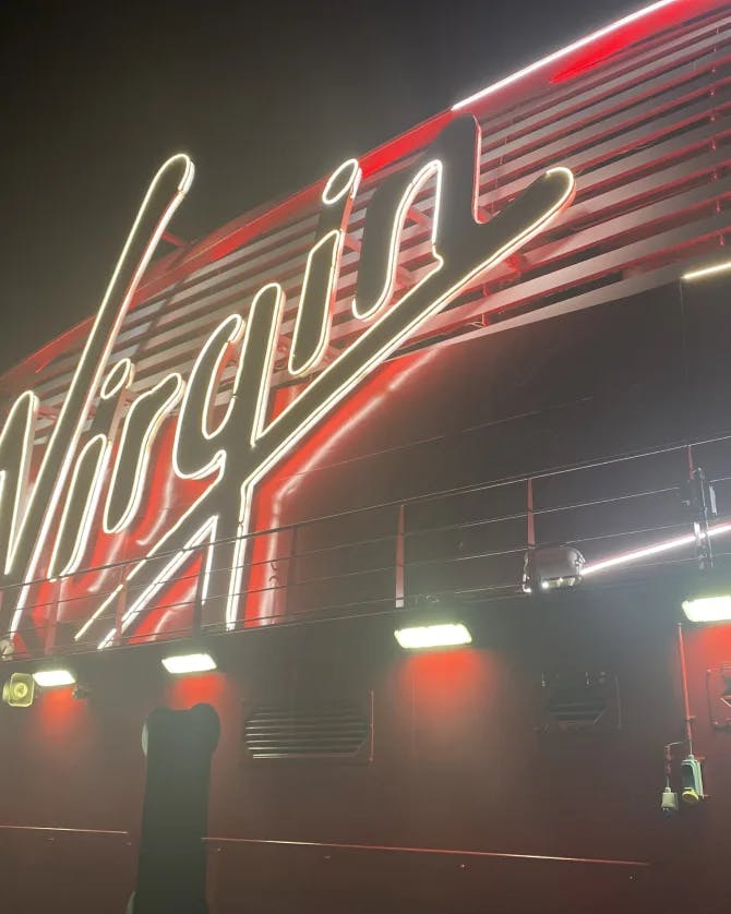 A photo of the Virgin Voyage sign lit up at night
