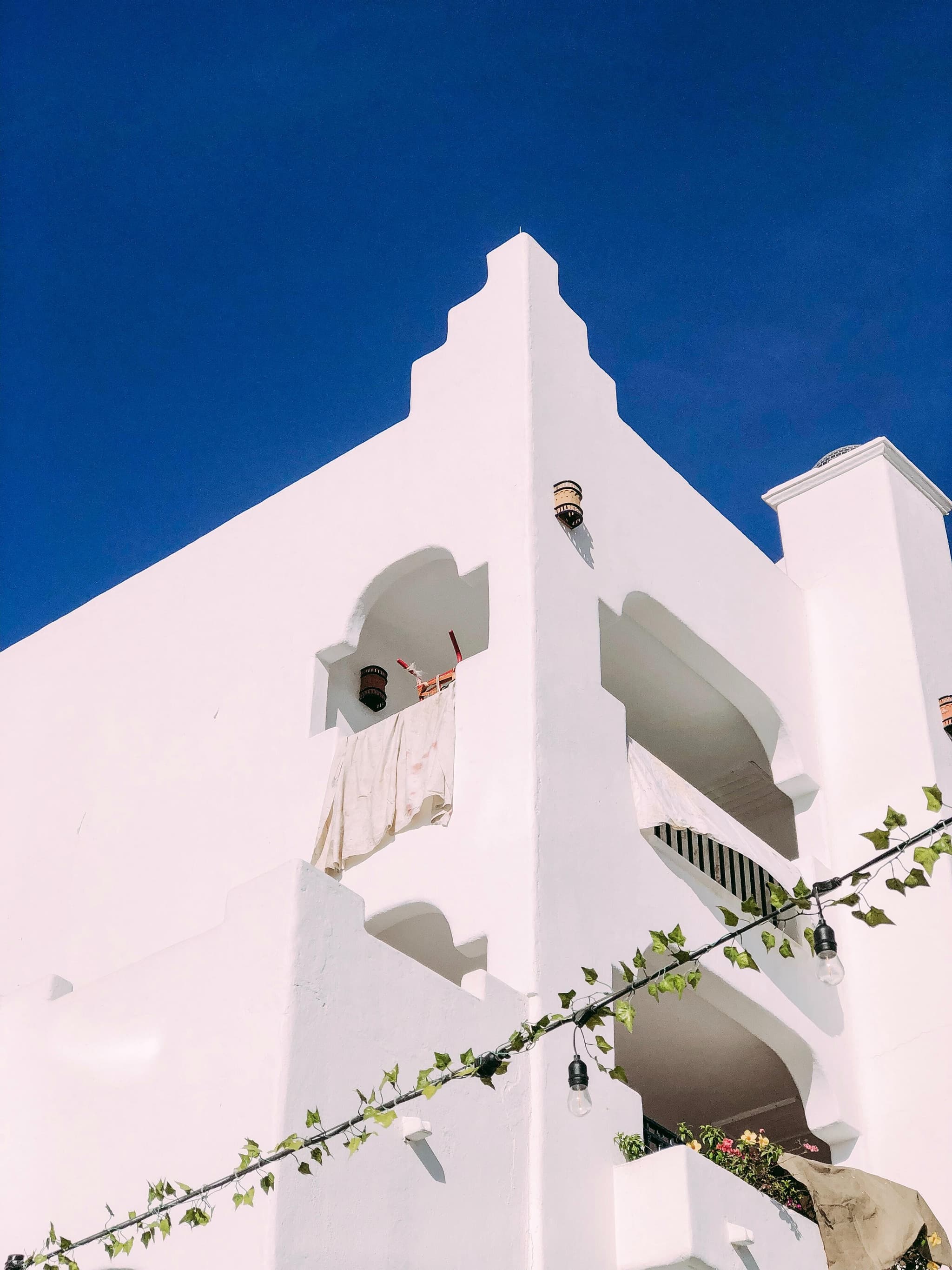 low-angle shot of a white building against a royal blue sky