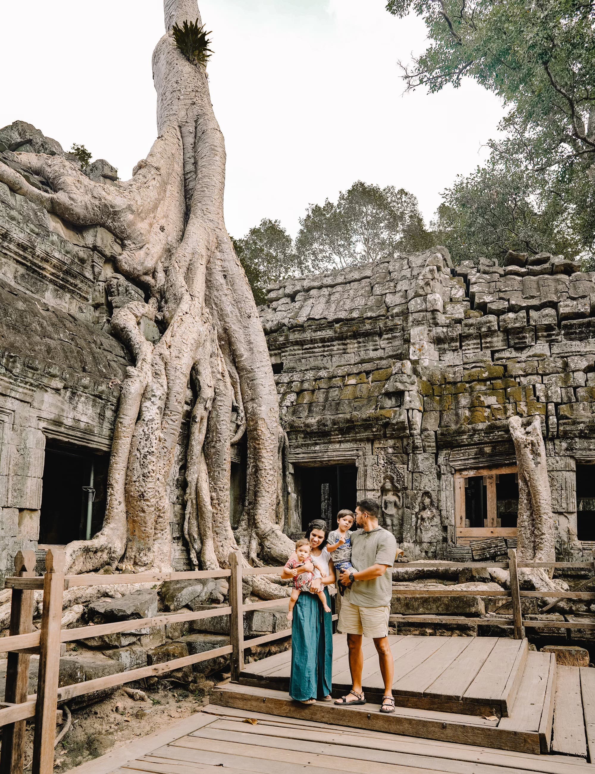 Maria, husband, and two young kids standing in front Ta Prohm Temple in Siem Reap, Cambodia.