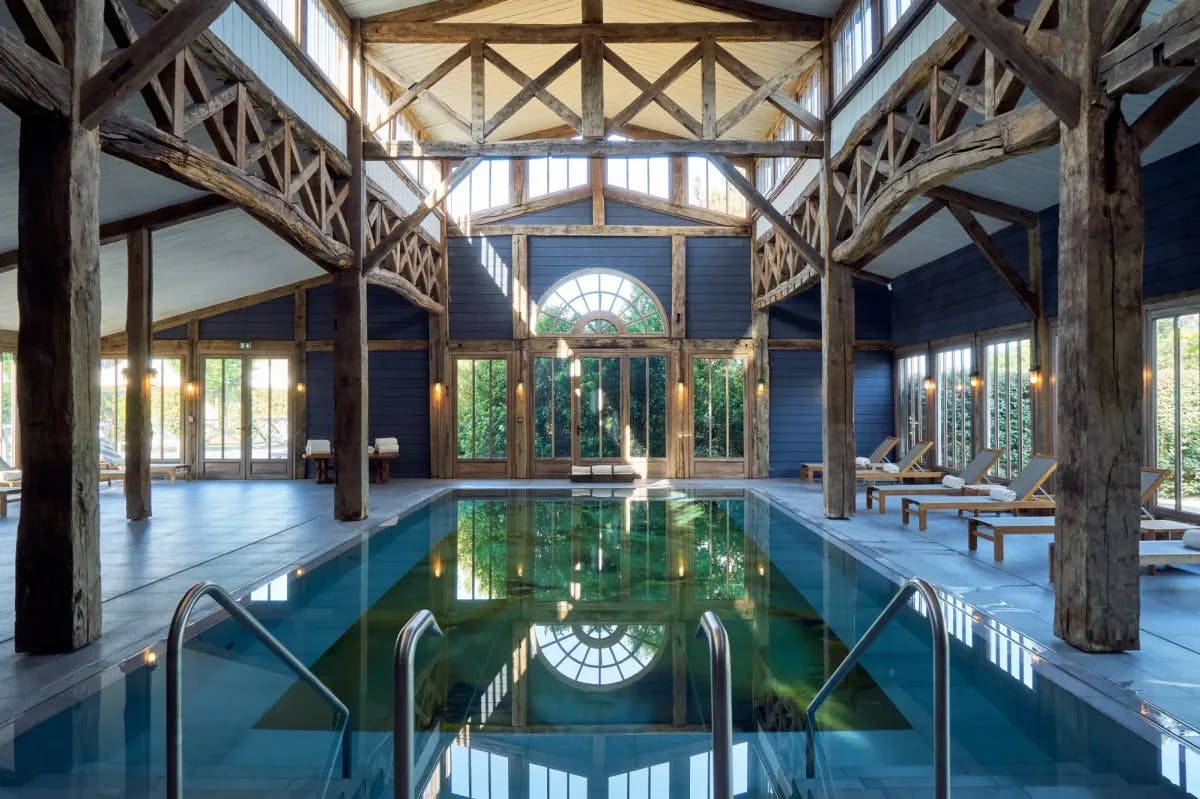 a large indoor pool in a giant atrium outfitted with wooden beams