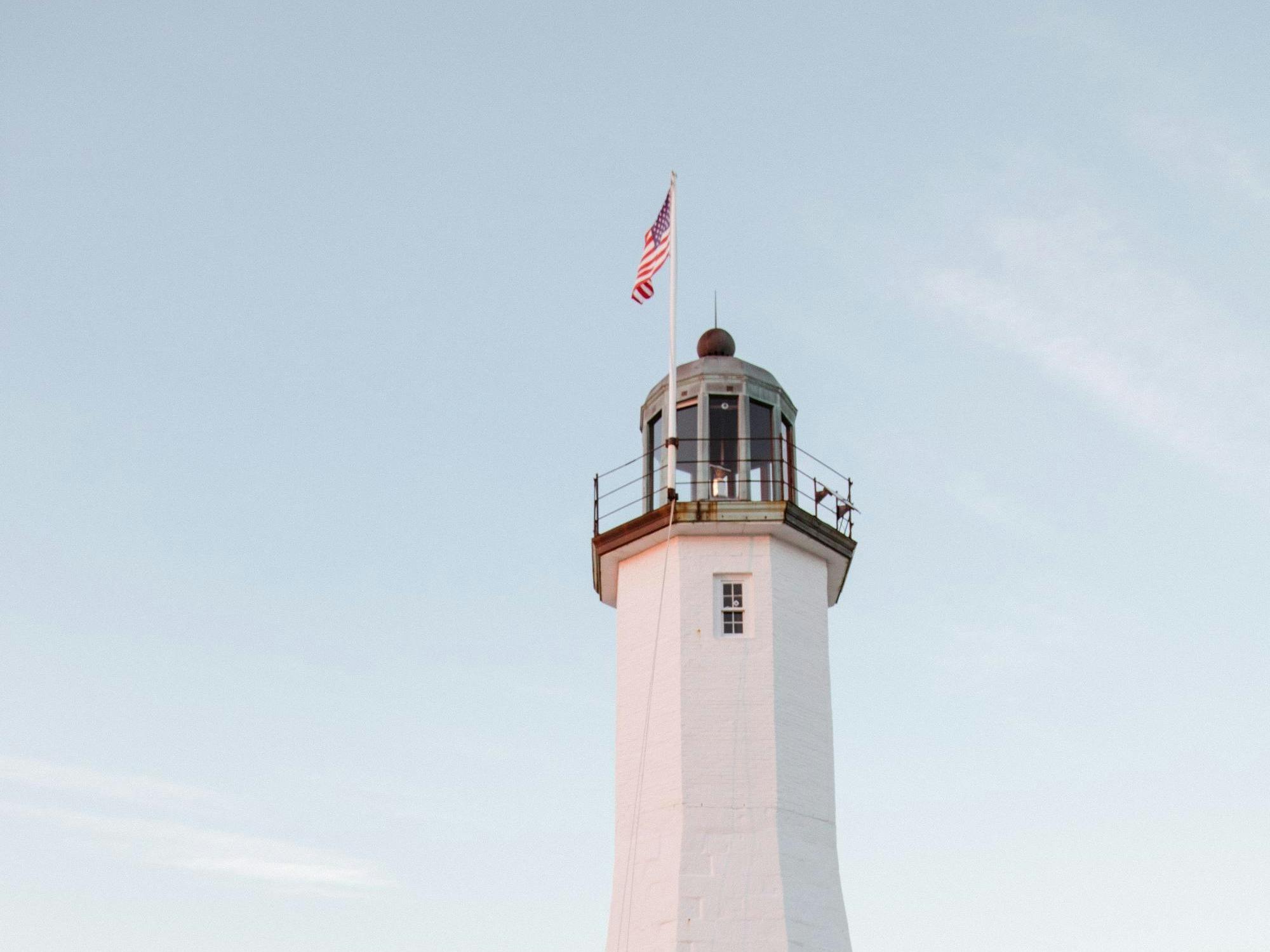 Massachusetts white lighthouse with American flag