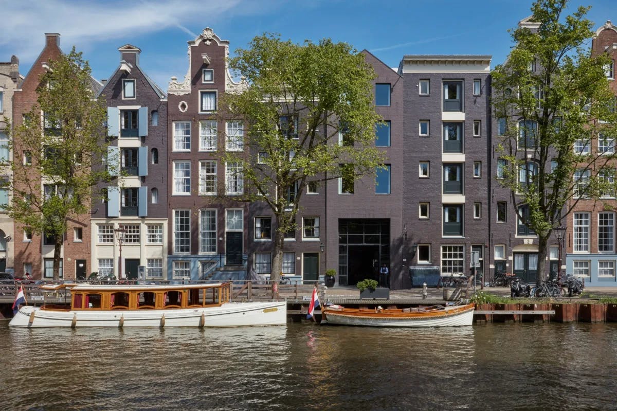a row of canal-side townhouses on a sunny day