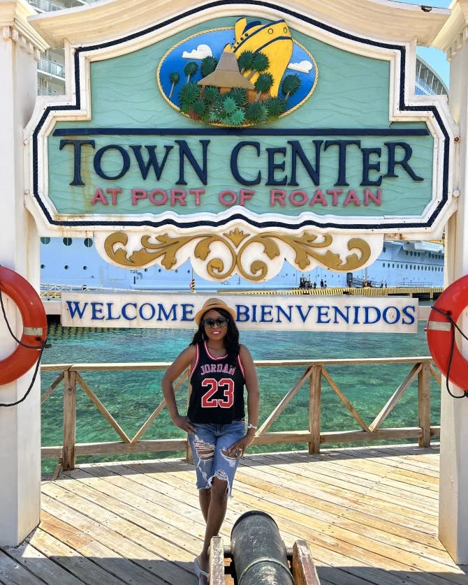 travel advisor stands in front of a large sign that reads, "town center"
