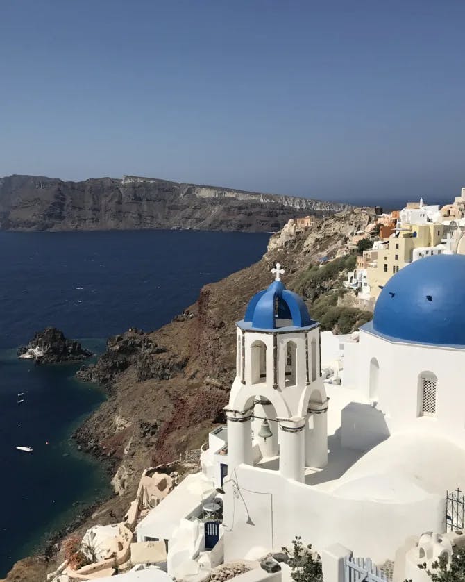 island in greece with white building with blue dome roofs