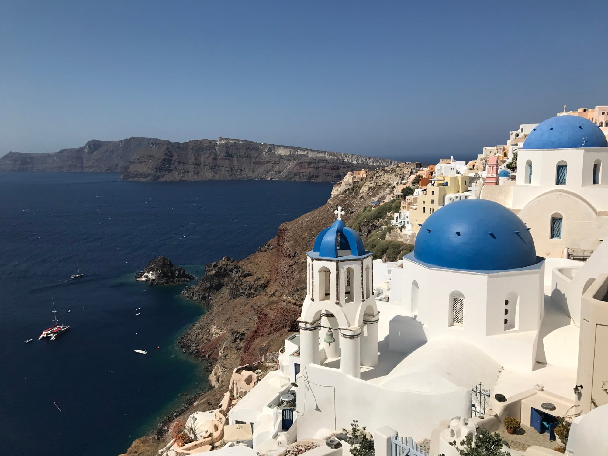 island in greece with white building with blue dome roofs