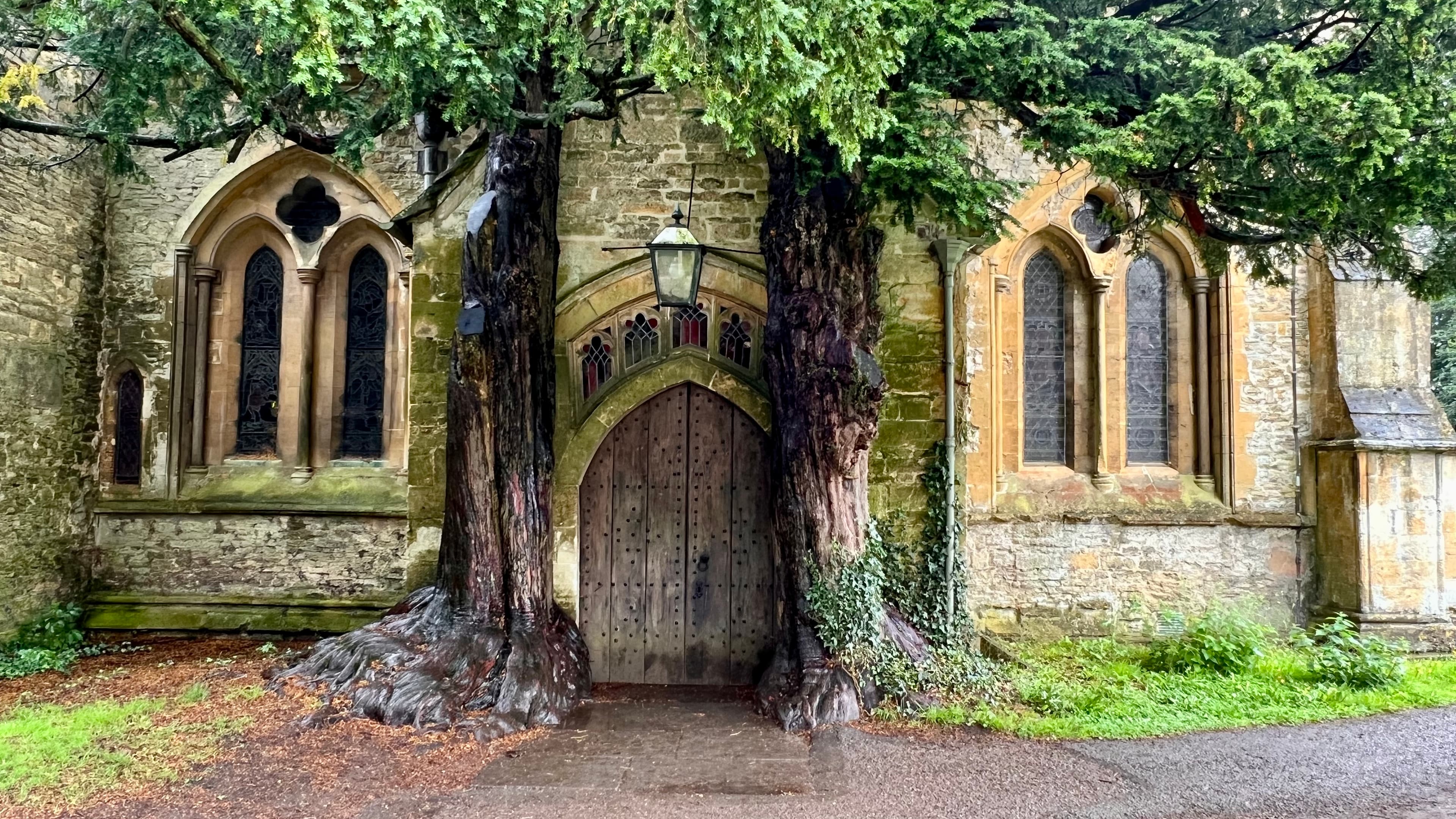Picture of St Edward's Church with two tree trunks surrounding the entrance