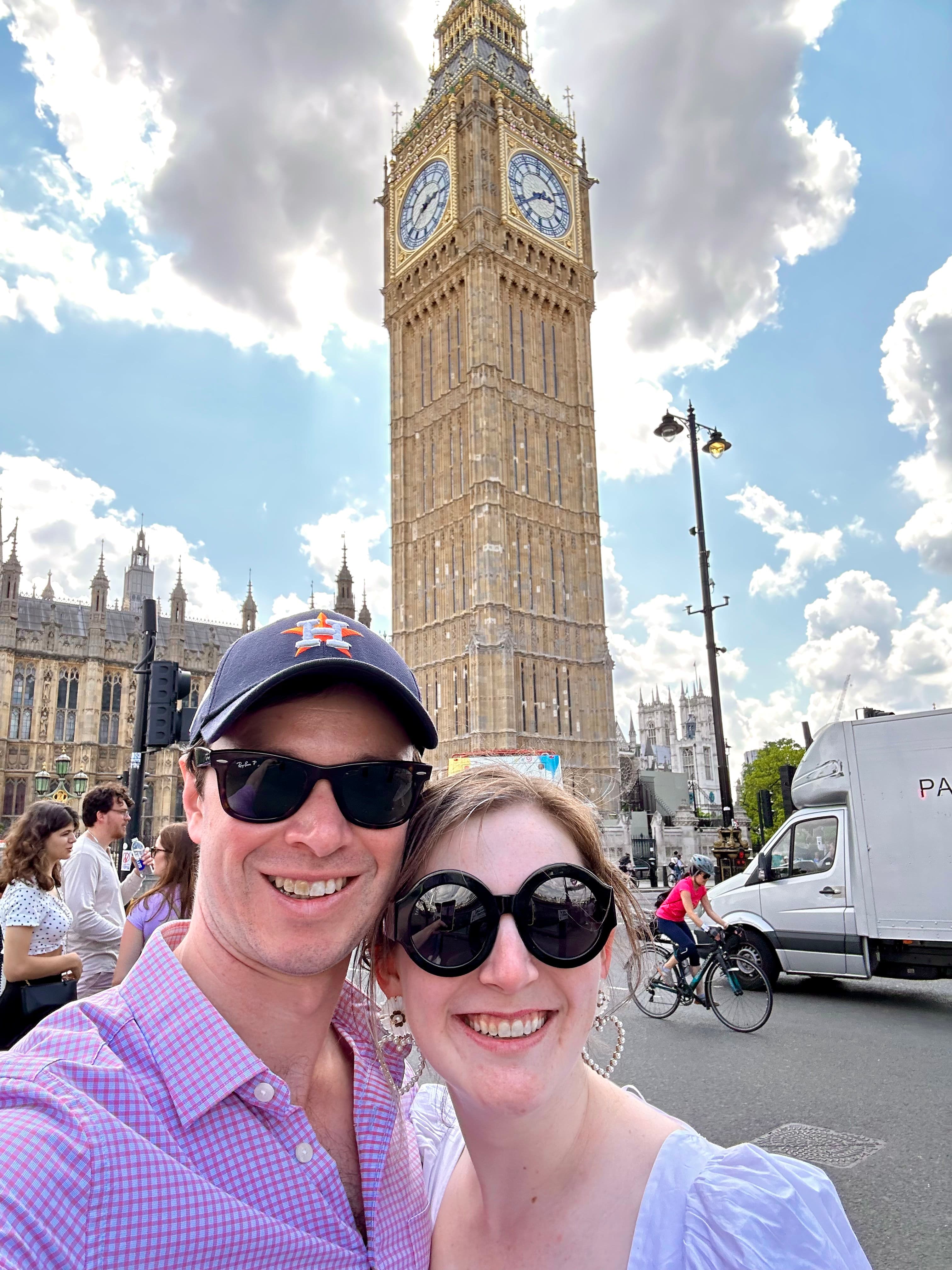 Couple posing in front of a clock tower