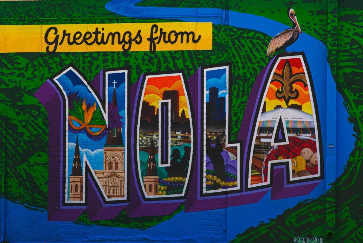 A colorful painted board saying Greetings from NOLA.