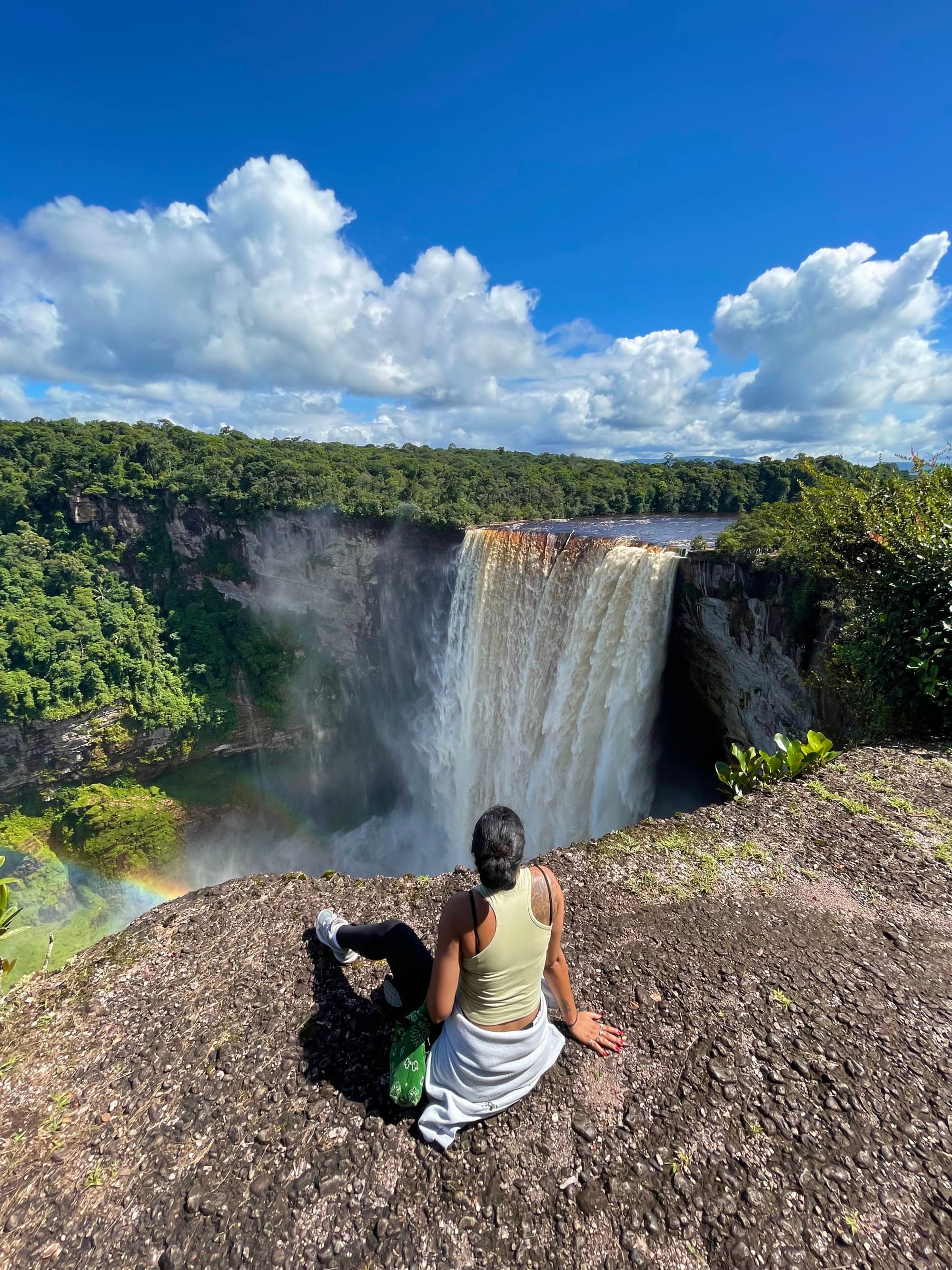 Travel advisor sites on the edge of rock cliff overlooking waterfall