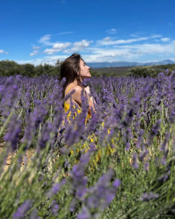 Stephanie posing in a lavender field in France under the blue sky.