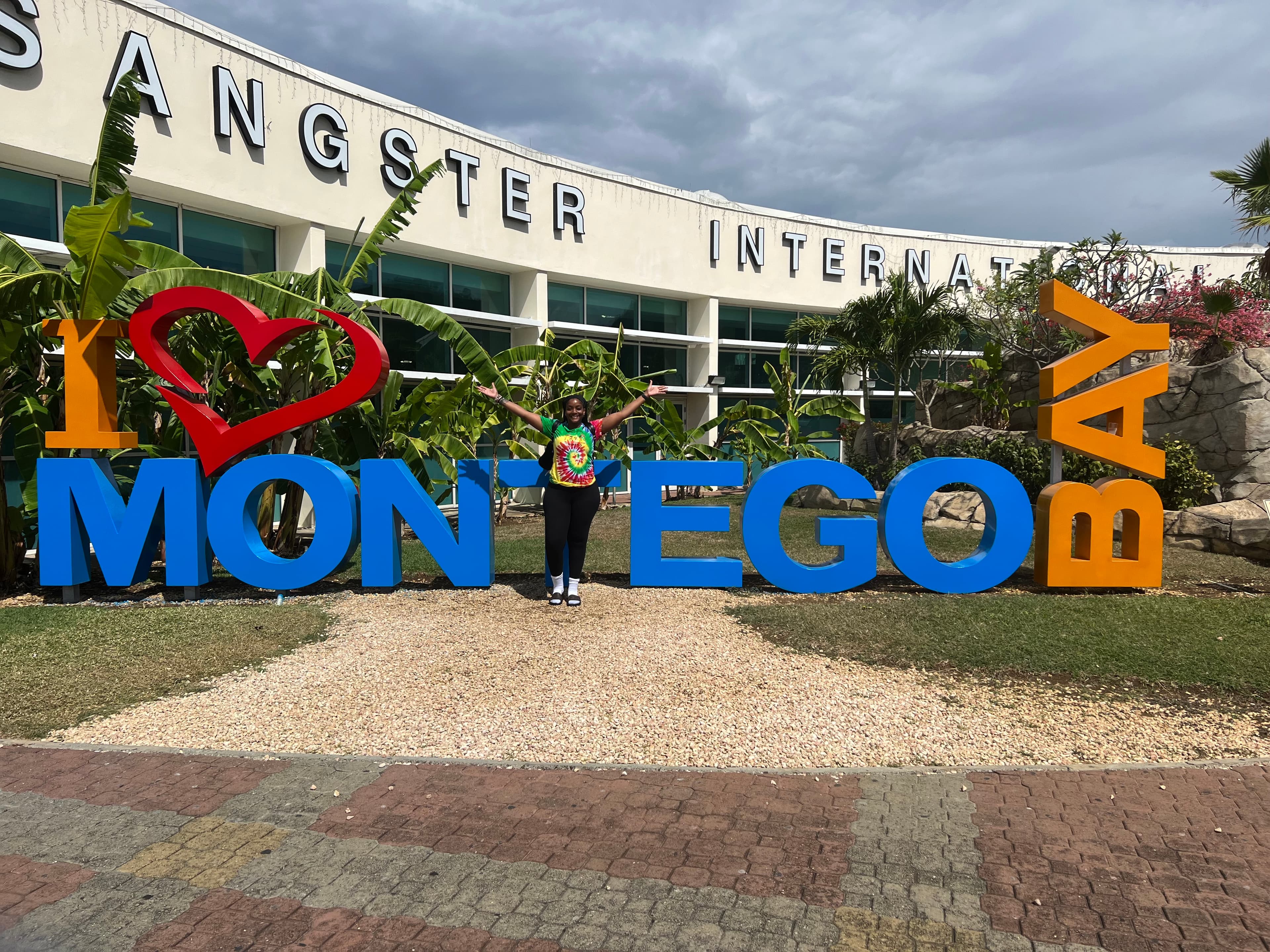 Travel advisor posing in front of a large sign reading "I love Montego Bay"