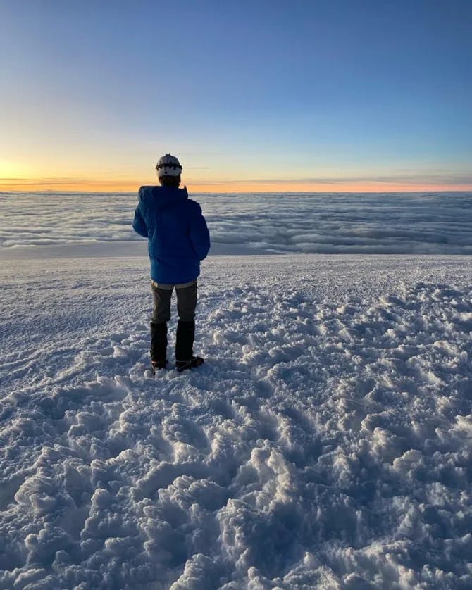 Stephen standing on snow with a sunset in the background