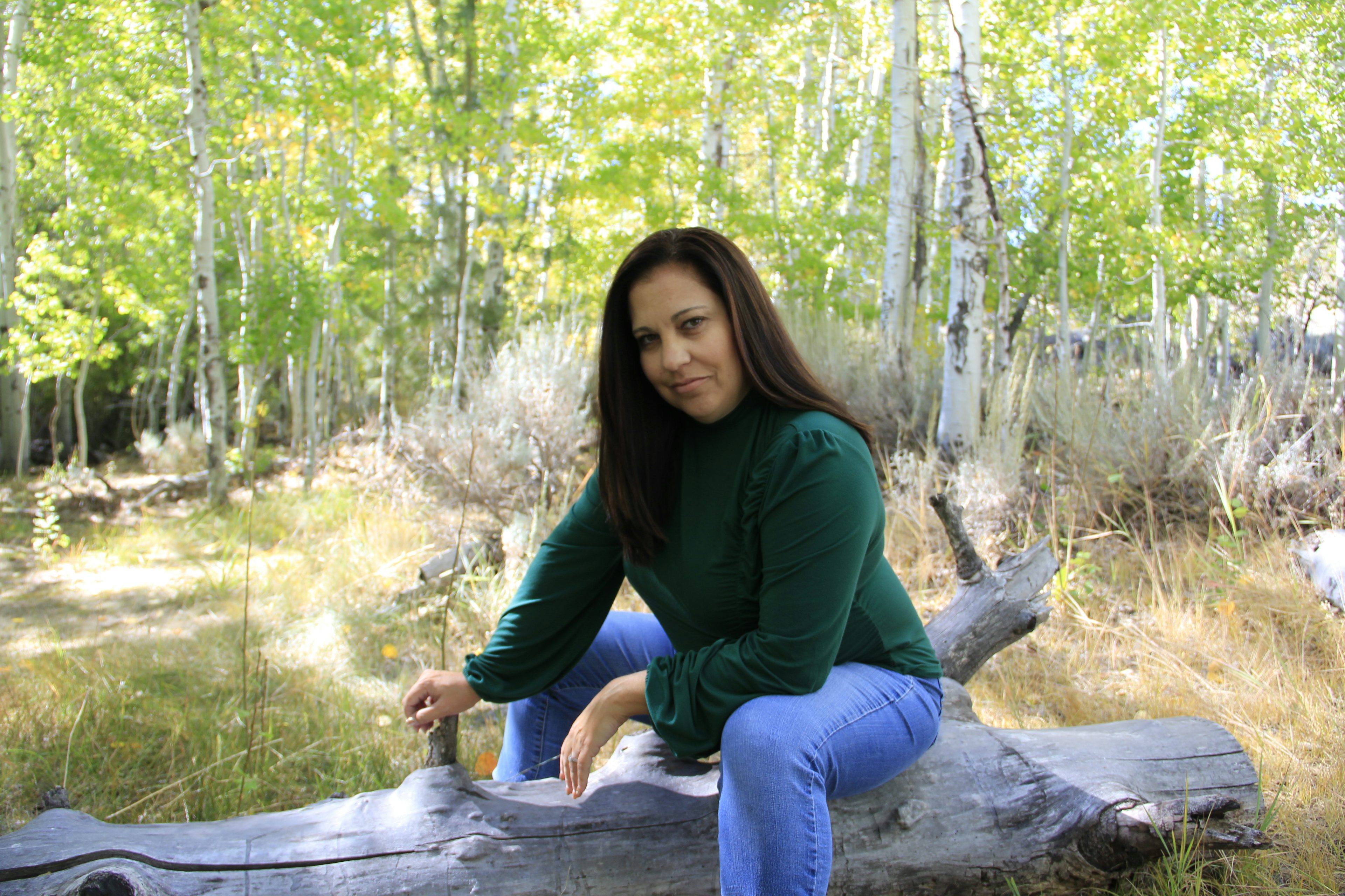 Travel advisor Alena Grace Saporsky in a green shirt in the forest.