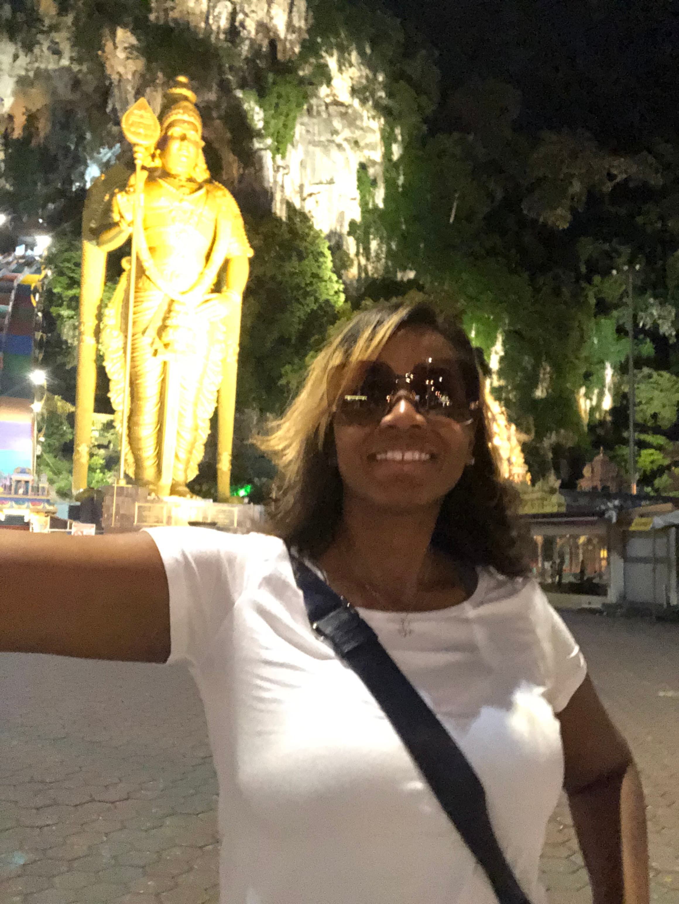 Erika posing in front of a large golden statue